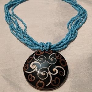 Beaded multi-strand necklace with brown pendant